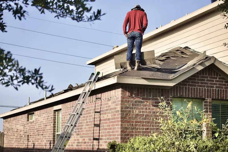 Professional roofer working on a residential roof in Beekmantown